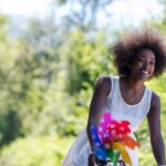 beautiful young African American women enjoy while riding a bicycle in the woods on a sunny summer day